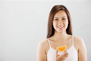 Девушка держит апельсин