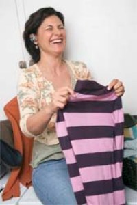 Женщина держит полосатый свитер