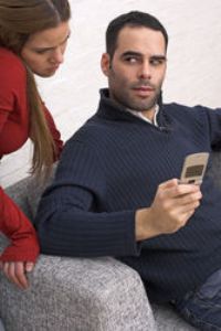 Женщина читает сообщения в телефоне мужчины