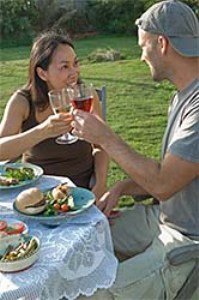 мужчина и женщина на пикнике пьют красное вино