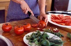 Женщина нарезает помидоры