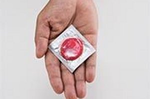 Упаковка с презервативом в мужской руке