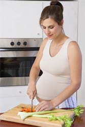 Беременная женщина готовит обед