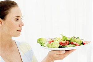 Женщина держит тарелку с салатом