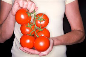 Женщина держит помидоры в руках