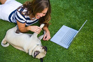 Девушка лежит на газоне с собакой