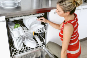 Девушка пользуется посудомоечной машиной
