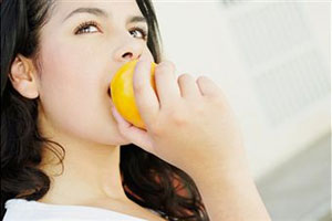 Девушка ест фрукт
