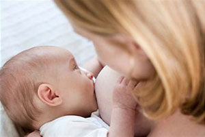 Женщина кормит грудью ребенка