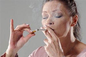 Женщина прикуривает сигарету