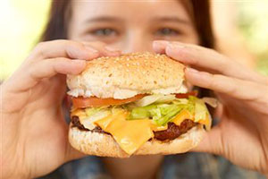 Девочка ест гамбургер