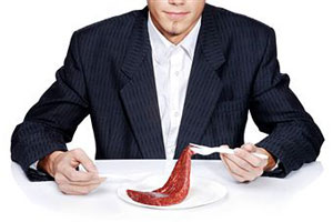 Мужчина ест мясо
