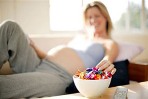Беременная женщина ест конфеты