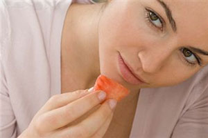 Женщина ест помидор