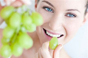 Женщина ест виноград