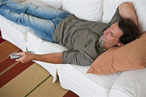 Мужчина в джинсах лежит на диване