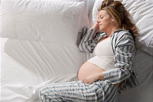 Беременная женщина лежит на кровате