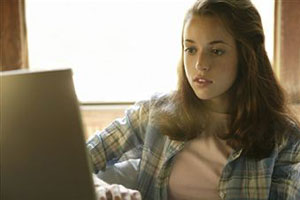 Девочка-подросток сидит за компьютером