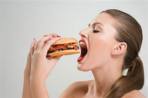 Девушка ест гамбургер