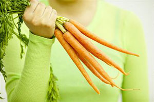 Девушка держит морковь