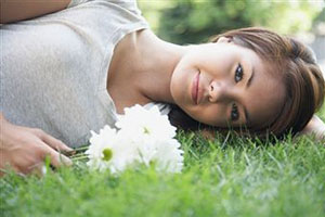 Девушка в футболке лежит на траве