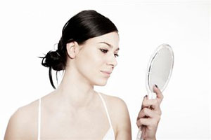 Женщина смотрит в зеркало