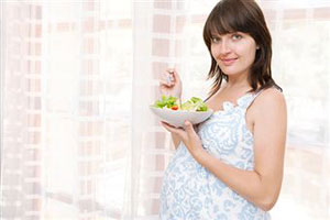 Беременная женщина ест обед