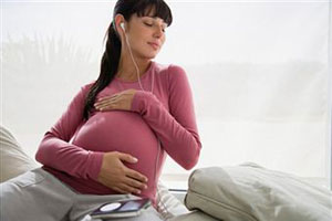 Беременная женщина слушает музыку