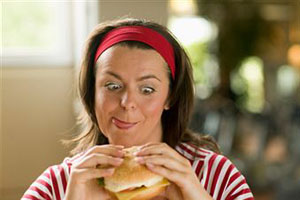 Женщина ест гамбургер