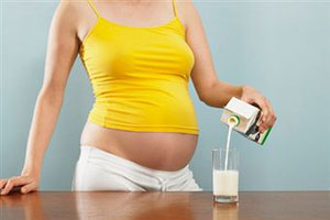 Беременная девушка пьет кефир