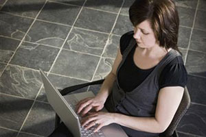 Девушка держит на коленях ноутбук