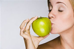 Девушка целует зеленое яблоко