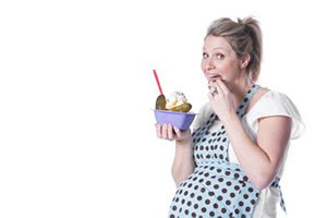 Беременная женщина ест огурцы