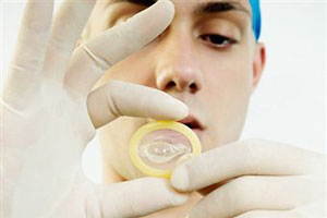 Исследователь держит в руках презерватив
