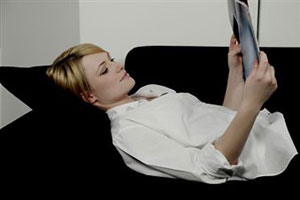 Девушка лежа читает гламурный журнал