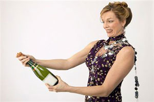 Женщина открывает бутылку шампанского