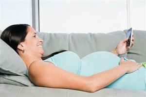 Беременная женщина смотрит в телефон