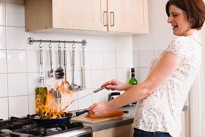Женщина готовит у плиты