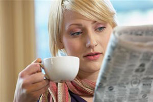 Девушка читает газету