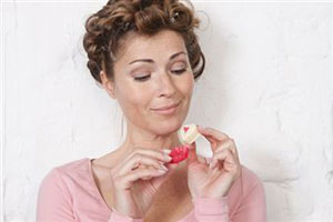 Женщина ест конфету