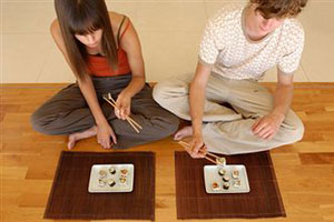 Молодая пара ужинает японской кухней