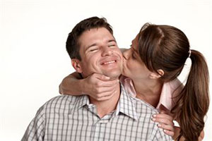 Девушка целует своего парня в щеку