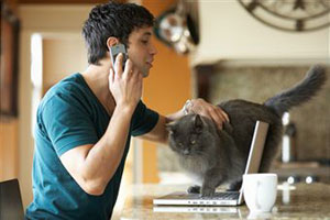 Парень разговаривает по телефону и гладит кота