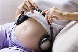 Беременная девушка слушает музыку
