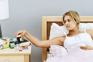 Женщина ледит в постеле с гриппом