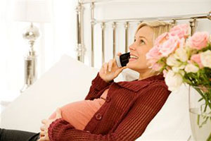 Беременная женщина говорит по телефону