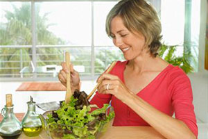 Женщина готовит салат с оливковым маслом
