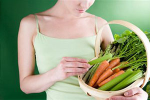Женщина держит корзину с овощами