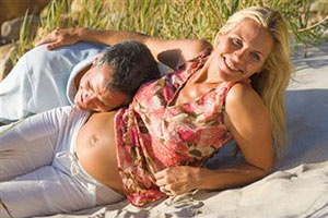 Беременная девушка лежит на пляже