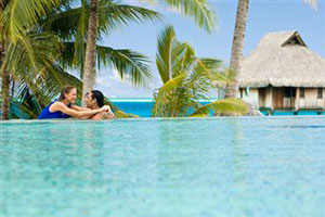 Молодая пара отдыхает у бассейна на остове Таити